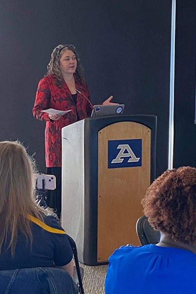 Bliss Institute Director Dr. J. Cherie Strachan stands at a podium