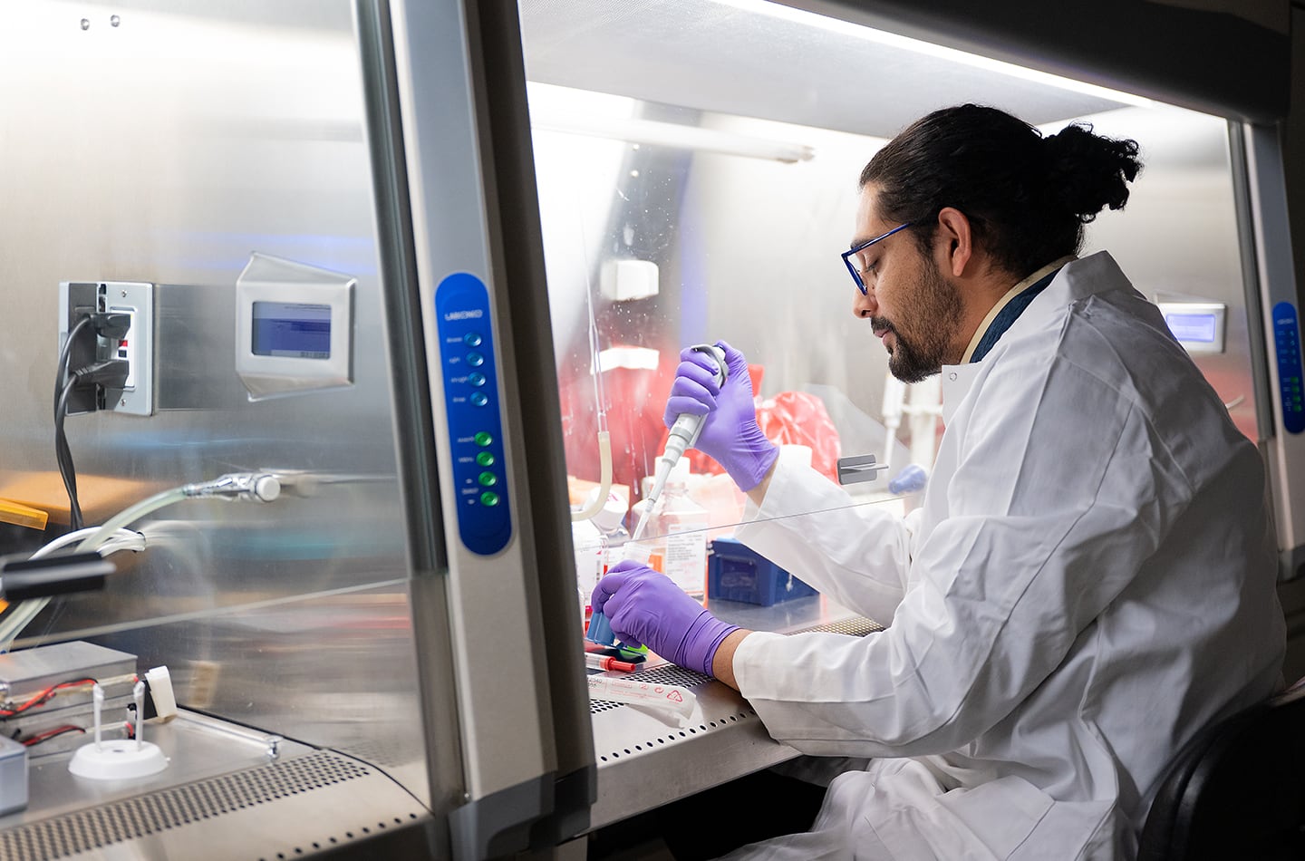 A biomedical engineering student working on a sample in a lab