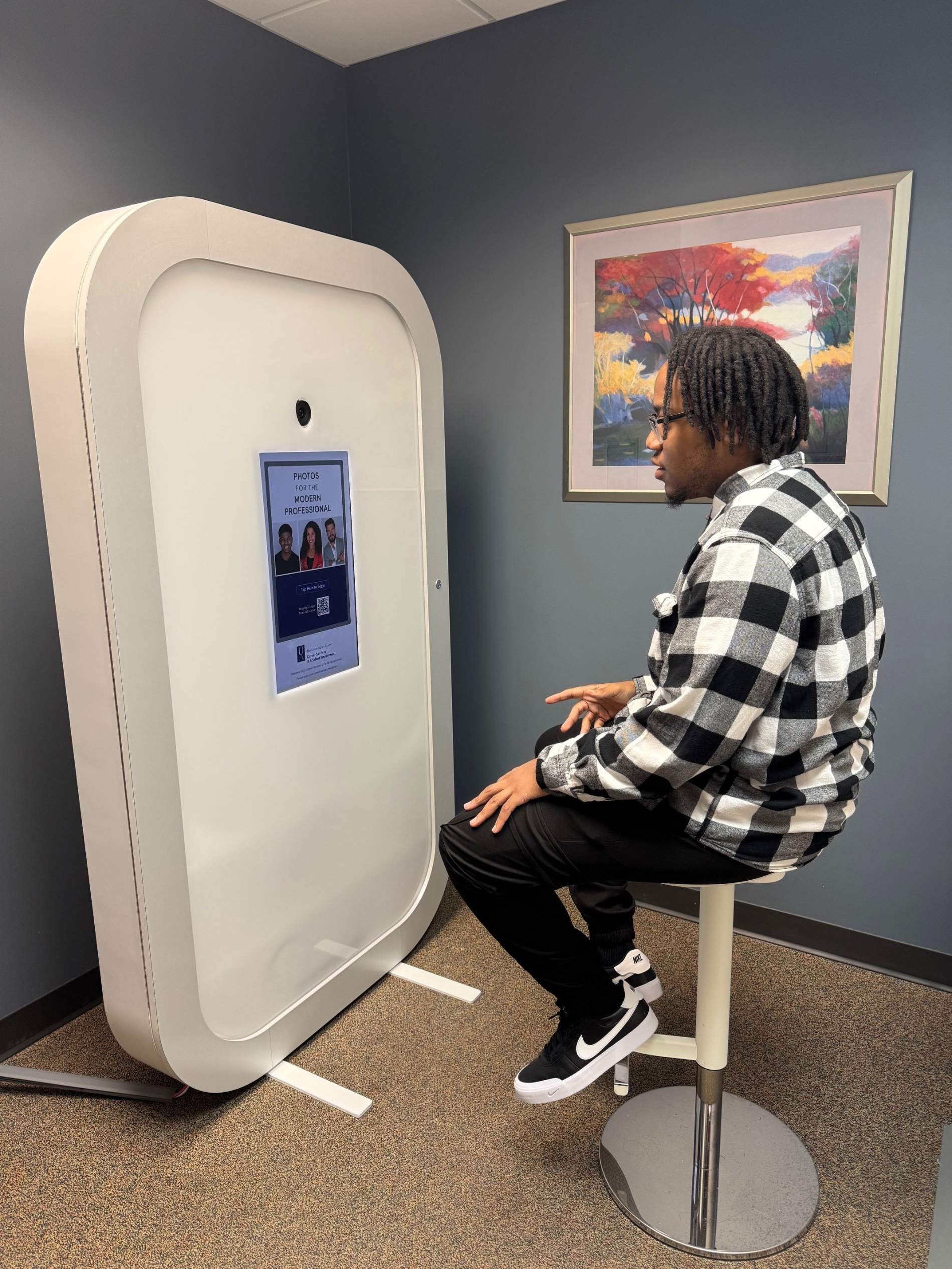 Photo of a student sitting at the Iris Headshot station