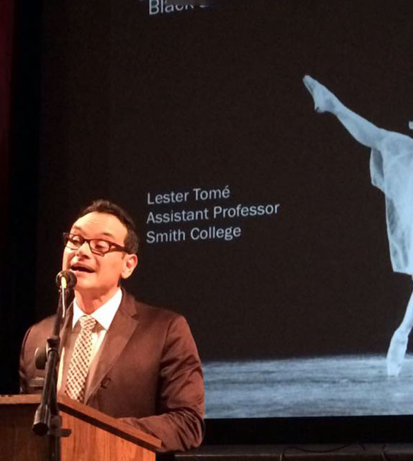 Guest speaker delivers a lecture at a podium while a presentation slide is projected behind him.
