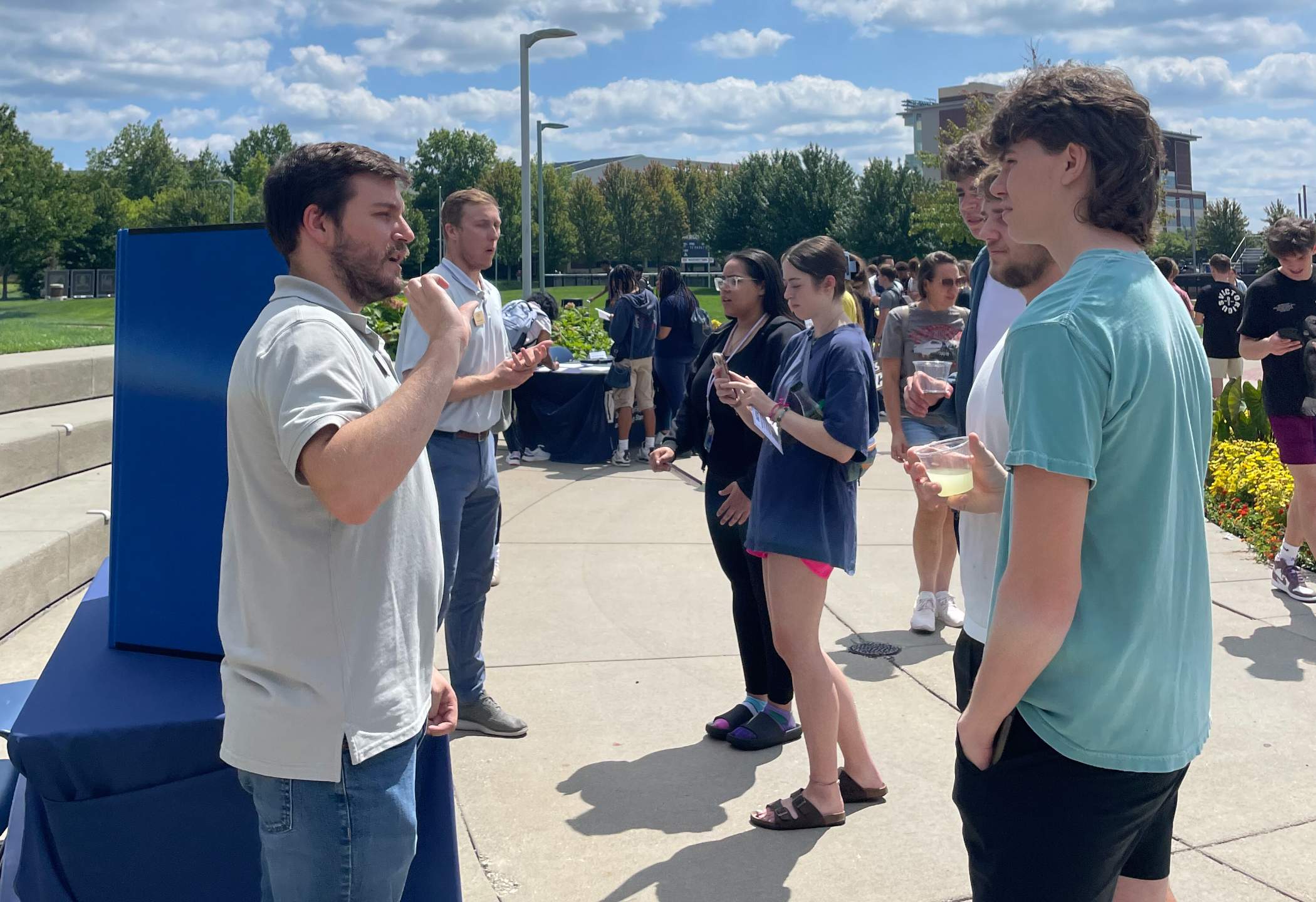 Photo of a UA staff member speaking with students at the Student Employment Job Fair held outside on Coleman Common at UA.