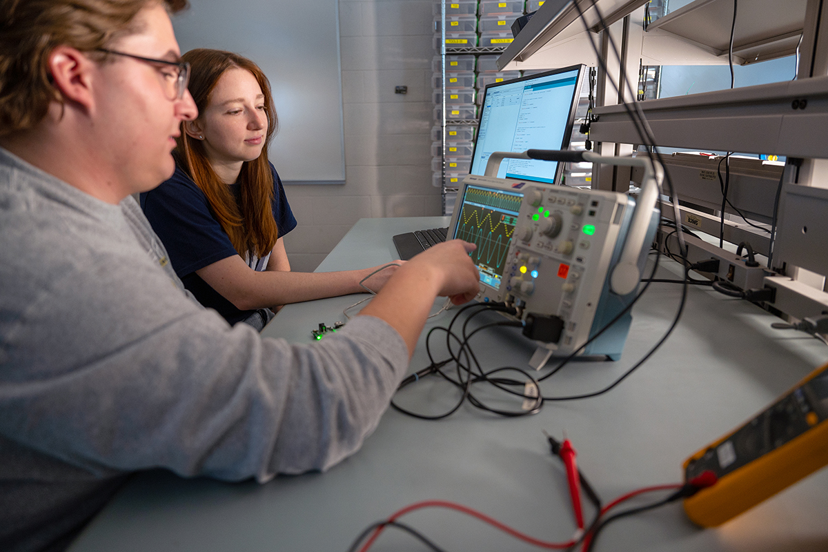 Electrical and computer engineering students working with equipment