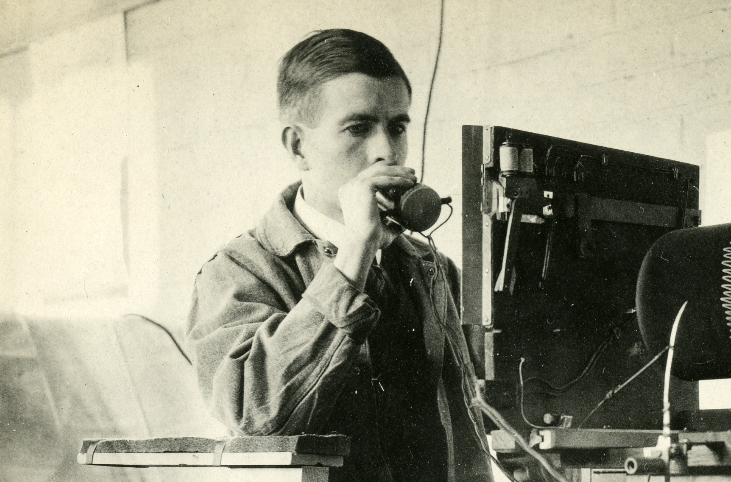 A man holding a device to his mouth in a laboratory setting