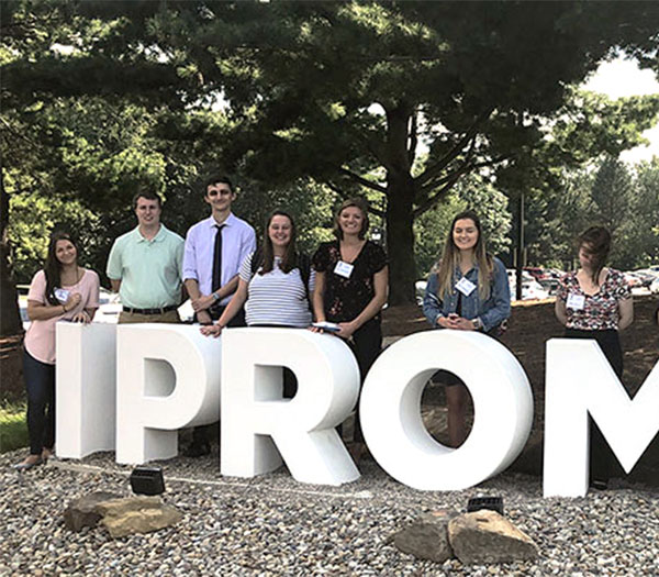 University of Akron education students pose behind large “IPROMISE” letters outdoors