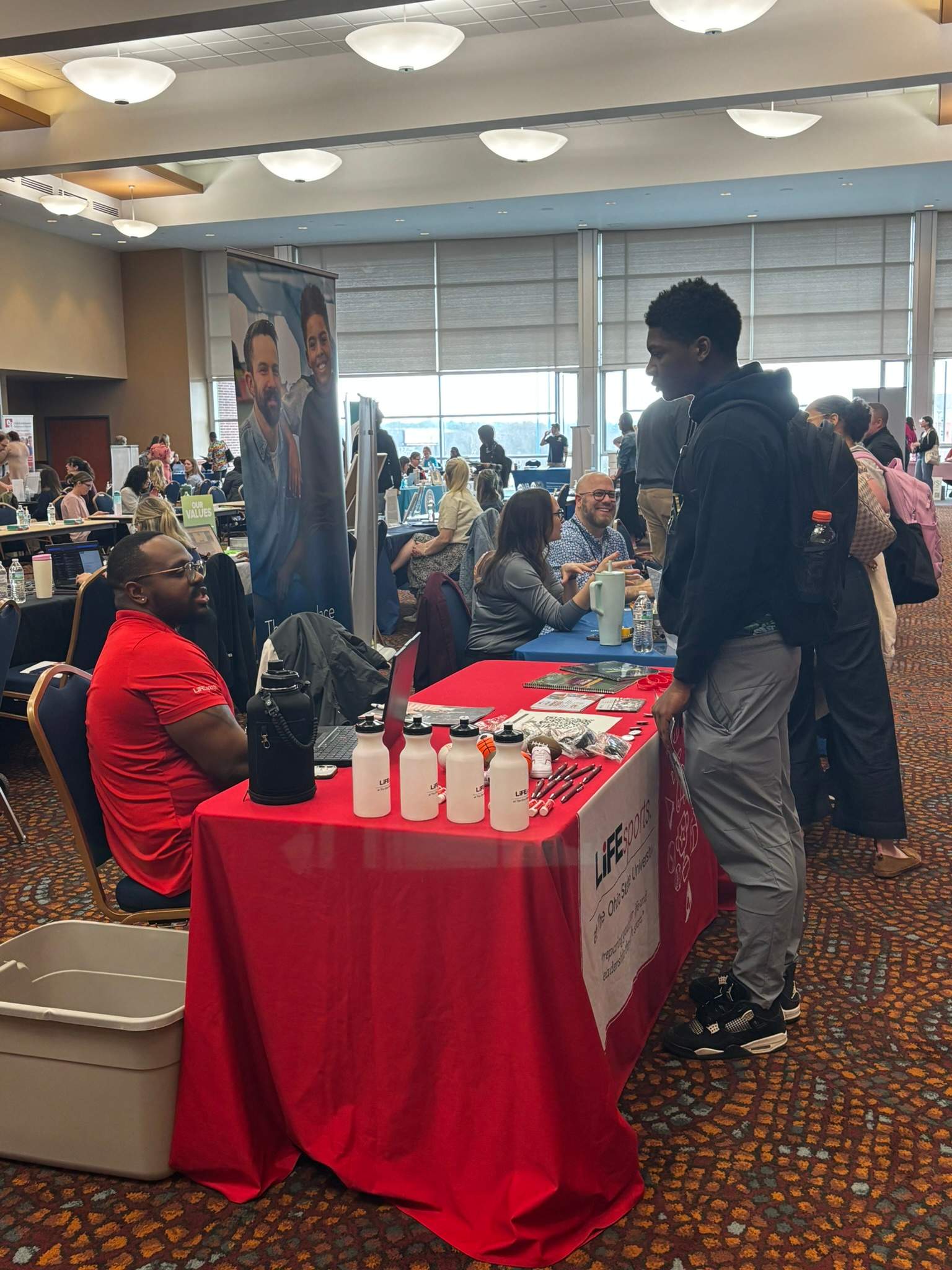 Photo of a student talking with an employer at a career fair in the Student Union on campus.