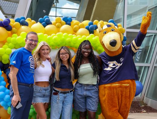President Nemer standing with Zippy and students