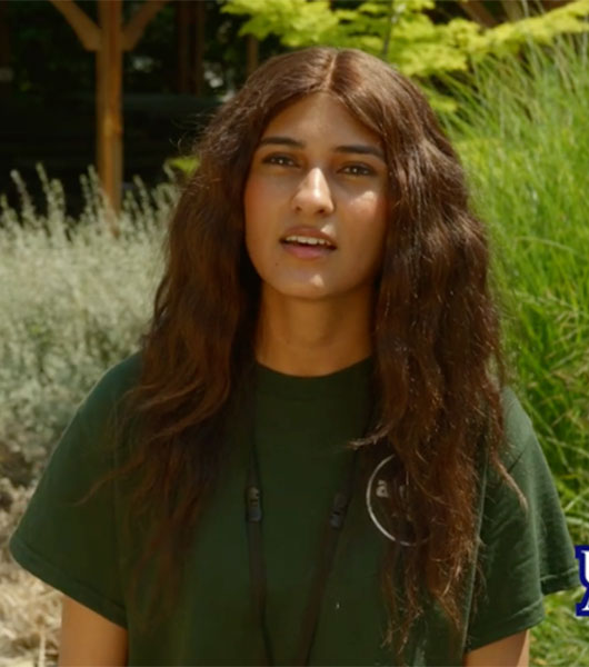 University of Akron biomedical science student speaks outdoors at the Akron Zoo during an interview about her undergraduate research experience.