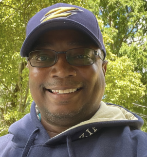 Thomas Holcombe smiles at the camera in a Zips hat and sweatshirt.