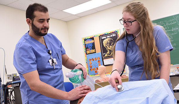 Two nursing students working together in a lab