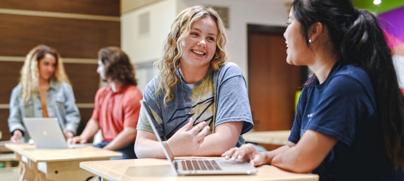 Two public relations students at Akron work on a project in the library.